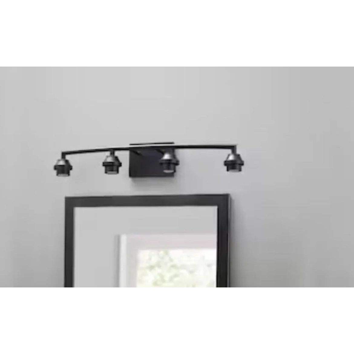 Style Selections 26.75-in 4-light black transitional vanity light fixture installed above bathroom mirror