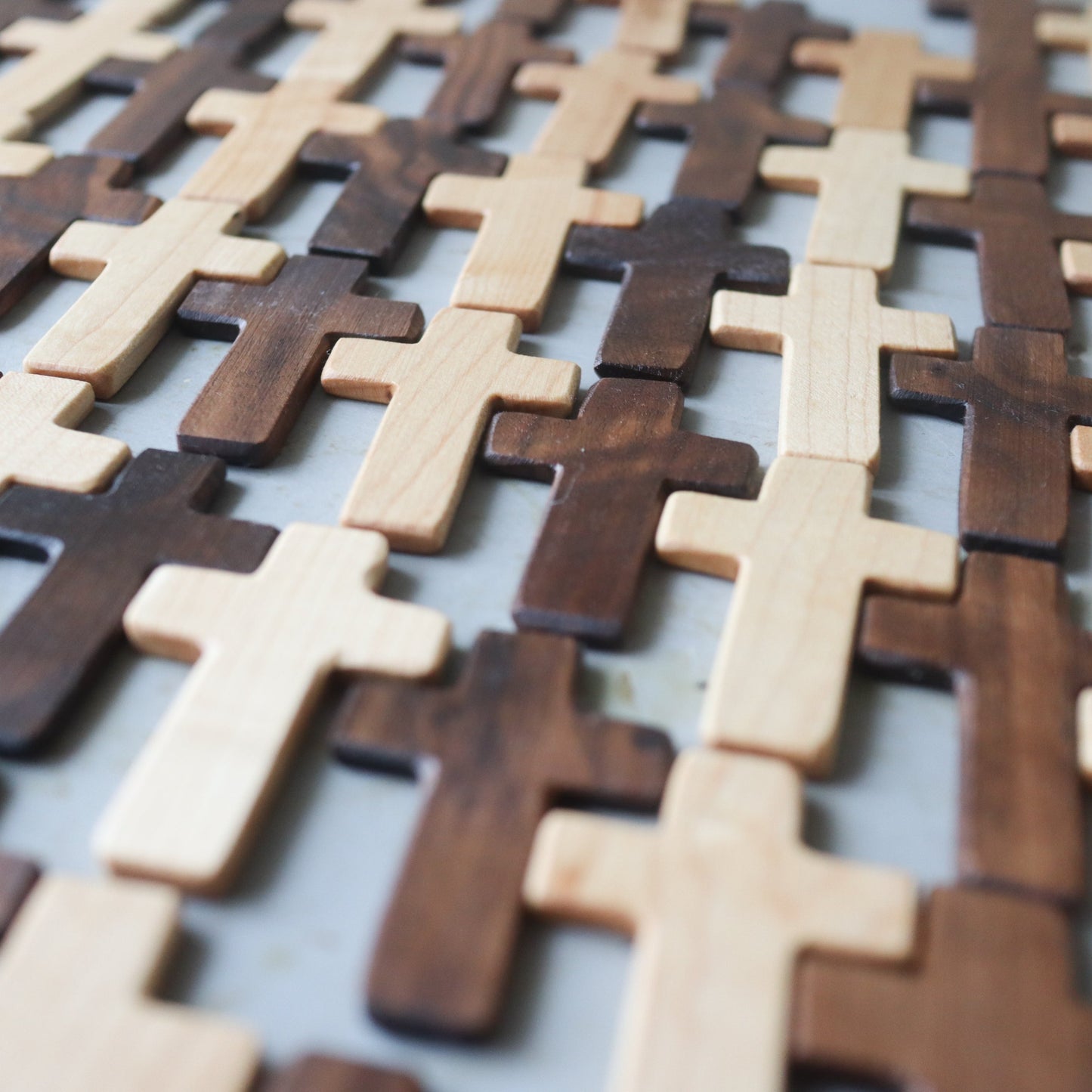 Handcrafted thin pocket crosses made from premium remnant woods including quilted maple, birdseye maple, and solid walnut, perfect for jewelry or bookmarks.