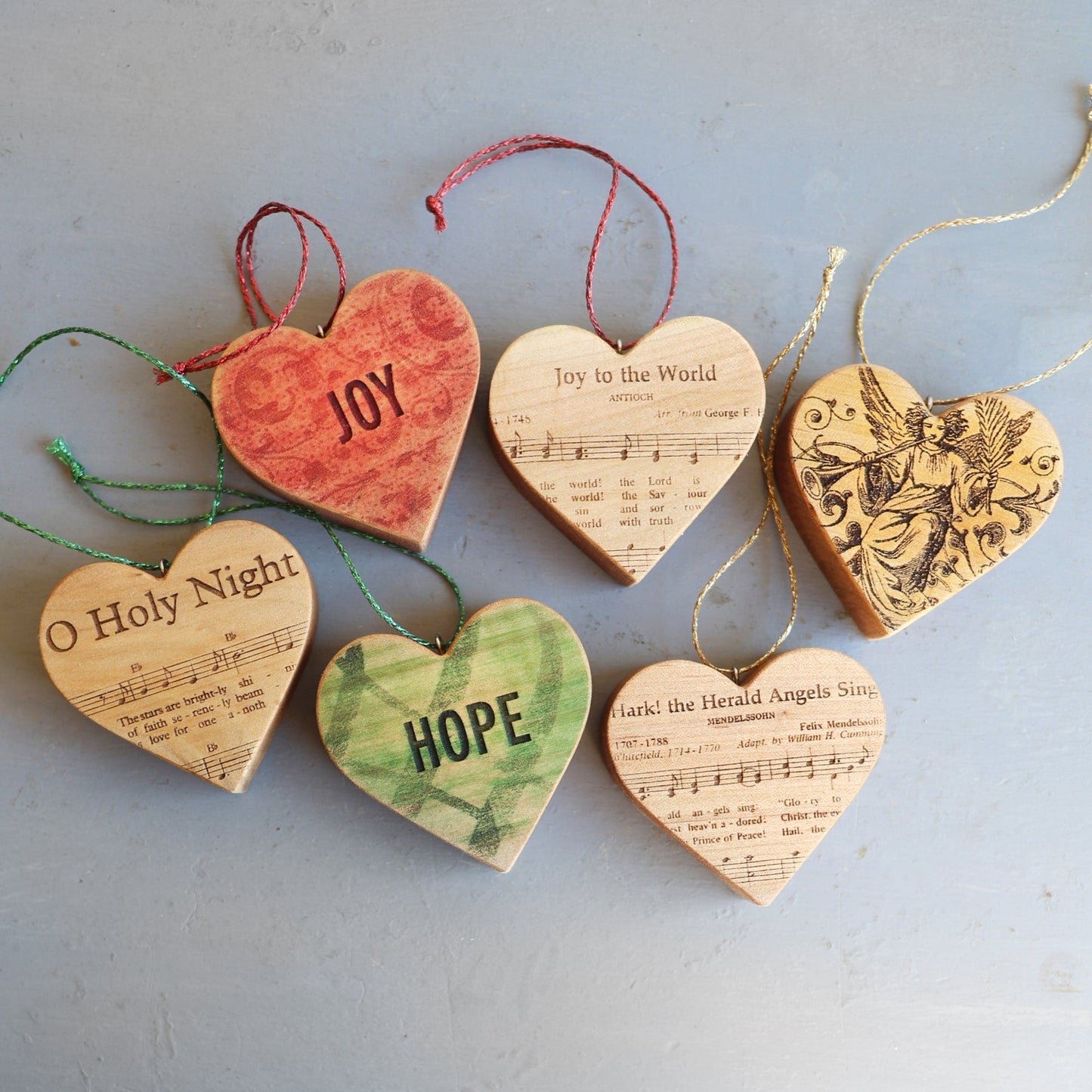 Set of six Christmas Carol Heart Ornaments with engraved sheet music and festive artwork on solid maple wood