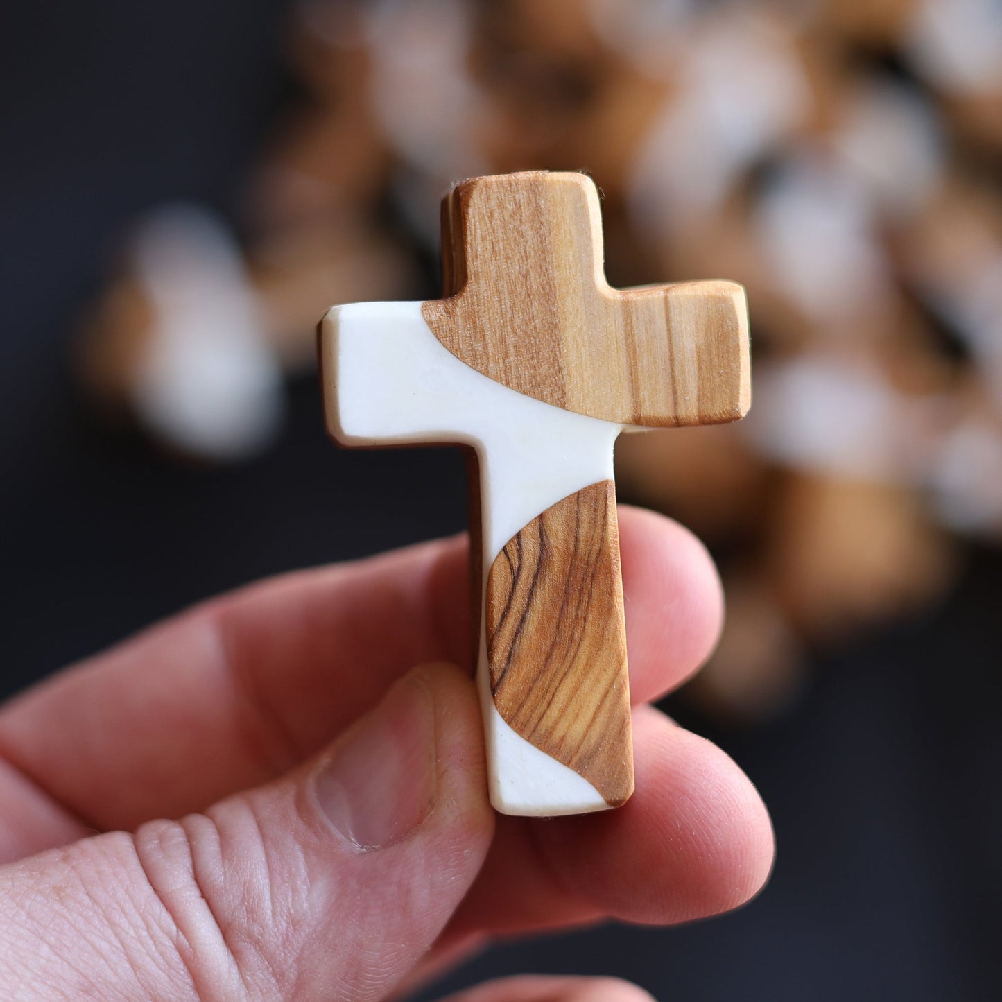 Handheld reclaimed olive wood and white resin pocket cross with natural grain patterns