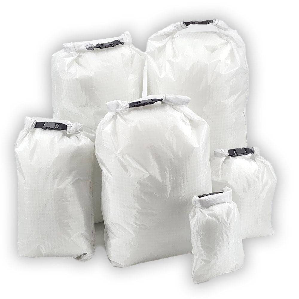 Set of six white ultralight roll top dry bags made from waterproof Challenge D50T fabric in various sizes for outdoor gear protection