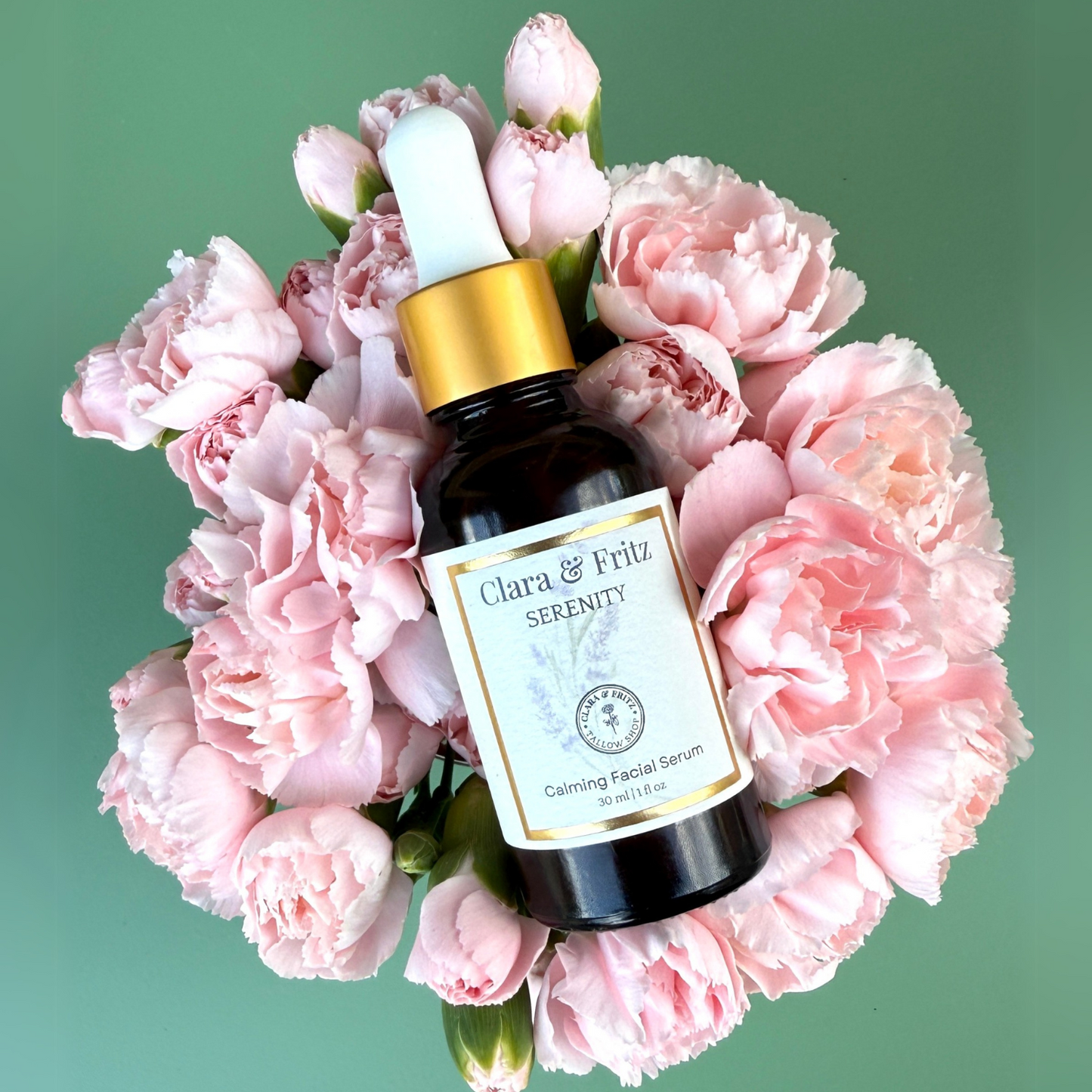 Bottle of Clara & Fritz Serenity Calming Facial Serum with dropper on a bed of pink flowers