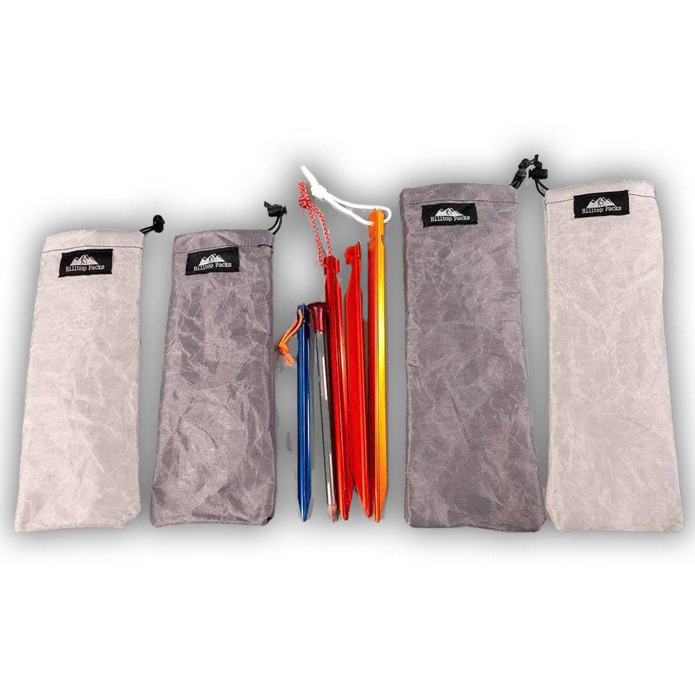 Ultralight and ultra-tough tent stake stuff sacks in various sizes with colorful tent stakes displayed