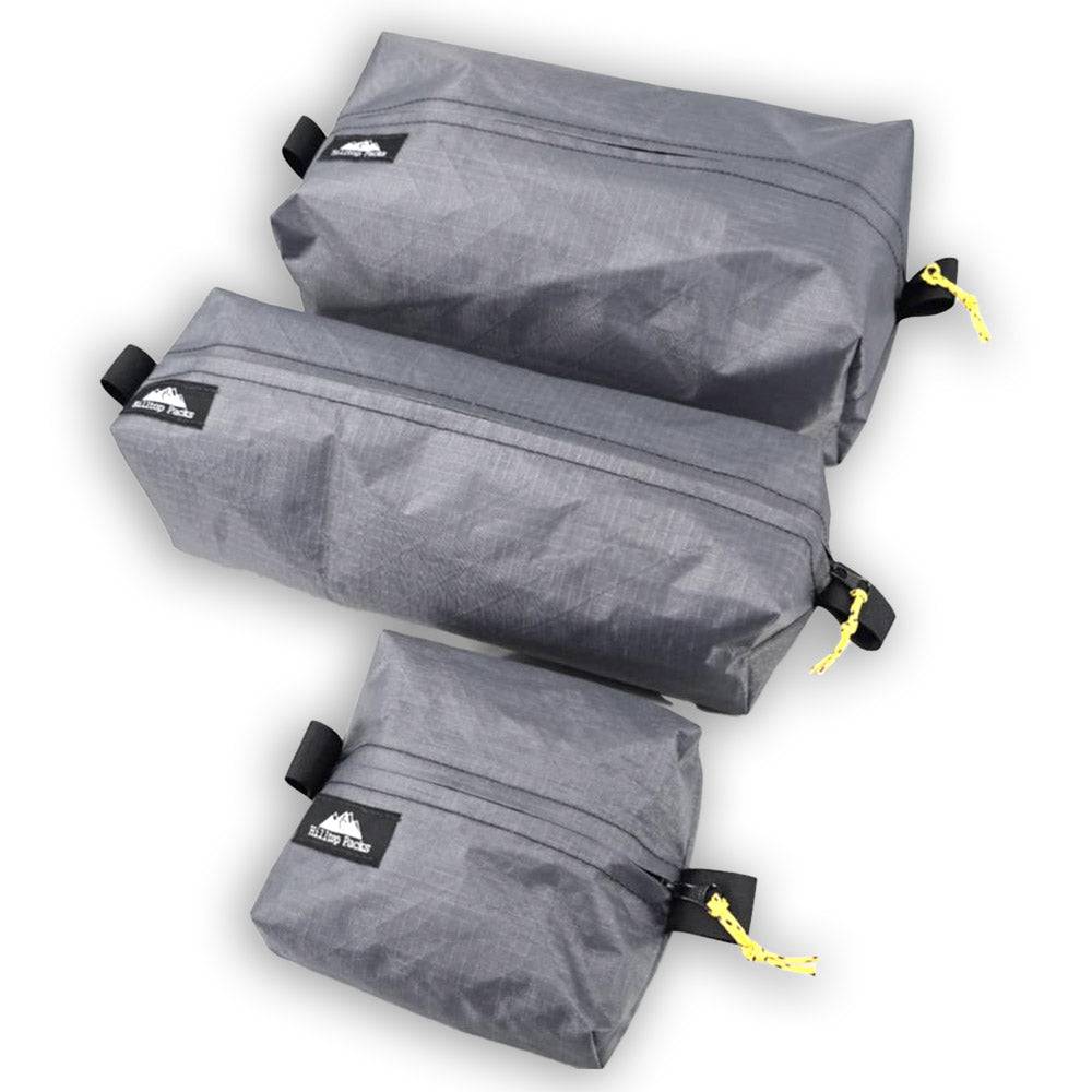 Set of three gray ultralight waterproof zipper boxes made from Ecopak EPLX200 fabric with yellow zipper pulls for hiking and backpacking gear organization