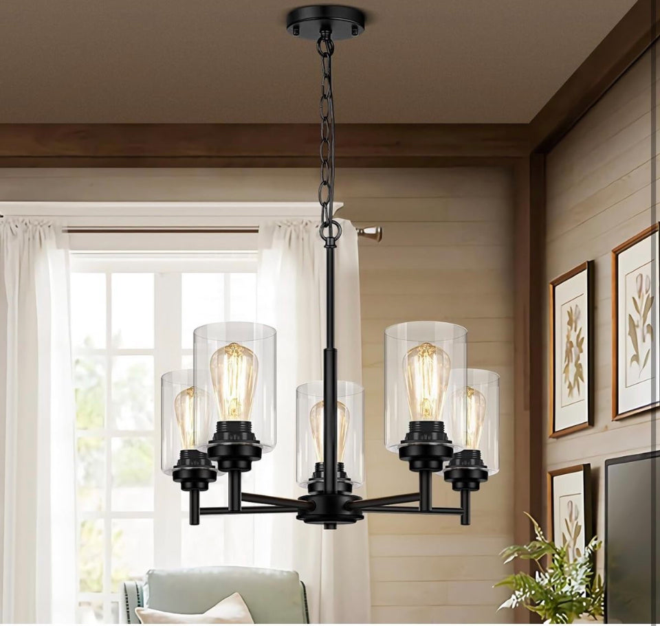 JAZAVA 5-lights modern chandelier with oil rubbed bronze finish and clear seeded glass shades hanging in living room.