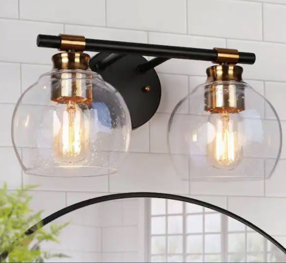 Zevniv14 14-inch 2-light modern black and brass bathroom vanity light with seeded glass globe shades mounted on black metal wall sconce.