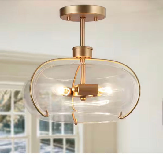 Modern semi flush mount light with dark gold finish and clear glass bowl shade