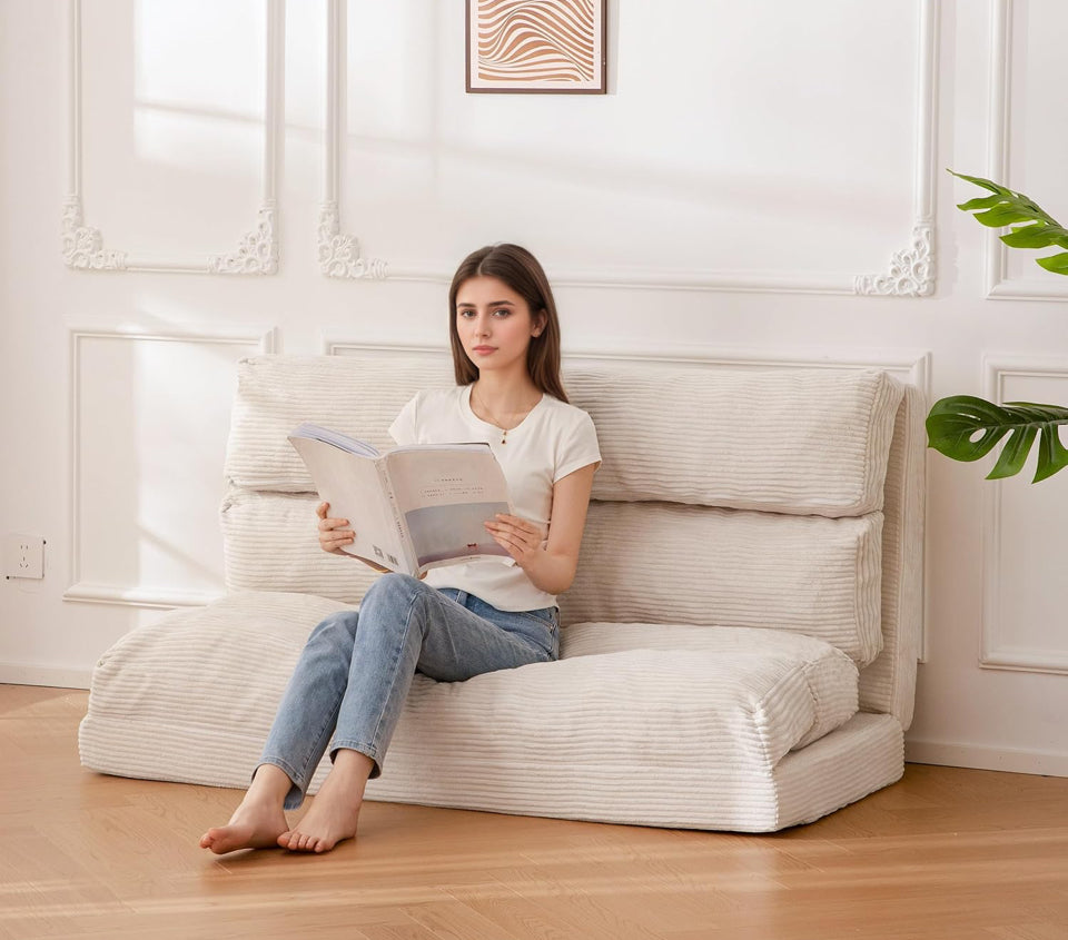 Woman sitting and reading on a foldable giant bean bag chair with removable faux fur cover in a bright living room