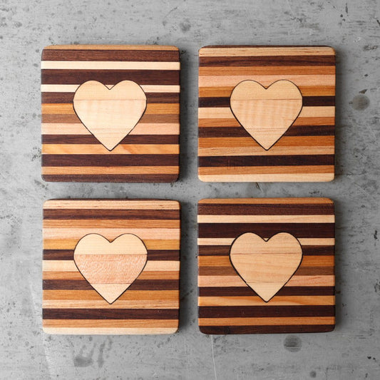 Set of four handmade wooden heart coasters with striped reclaimed wood and a solid maple heart center.