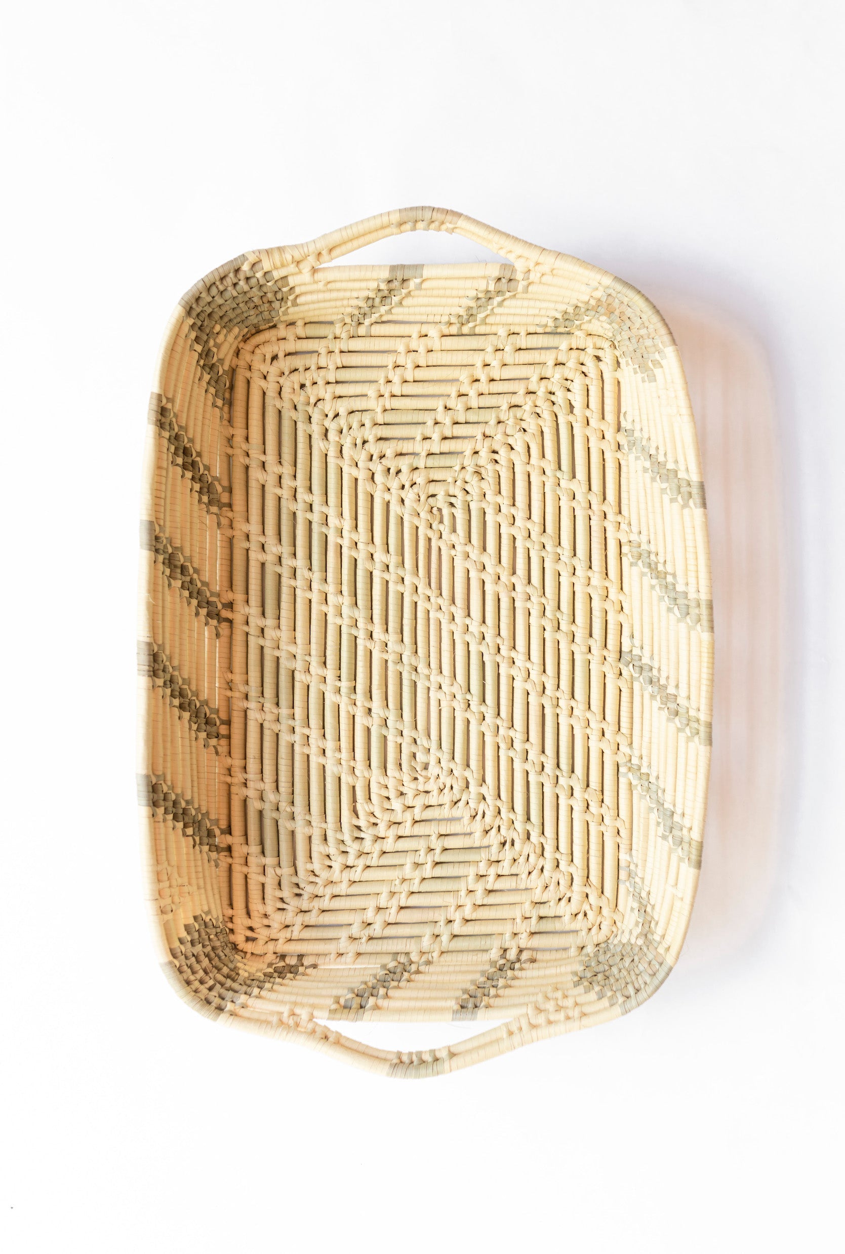 Handwoven rectangular basket tray made from locally sourced palm leaves with natural beige and brown pattern