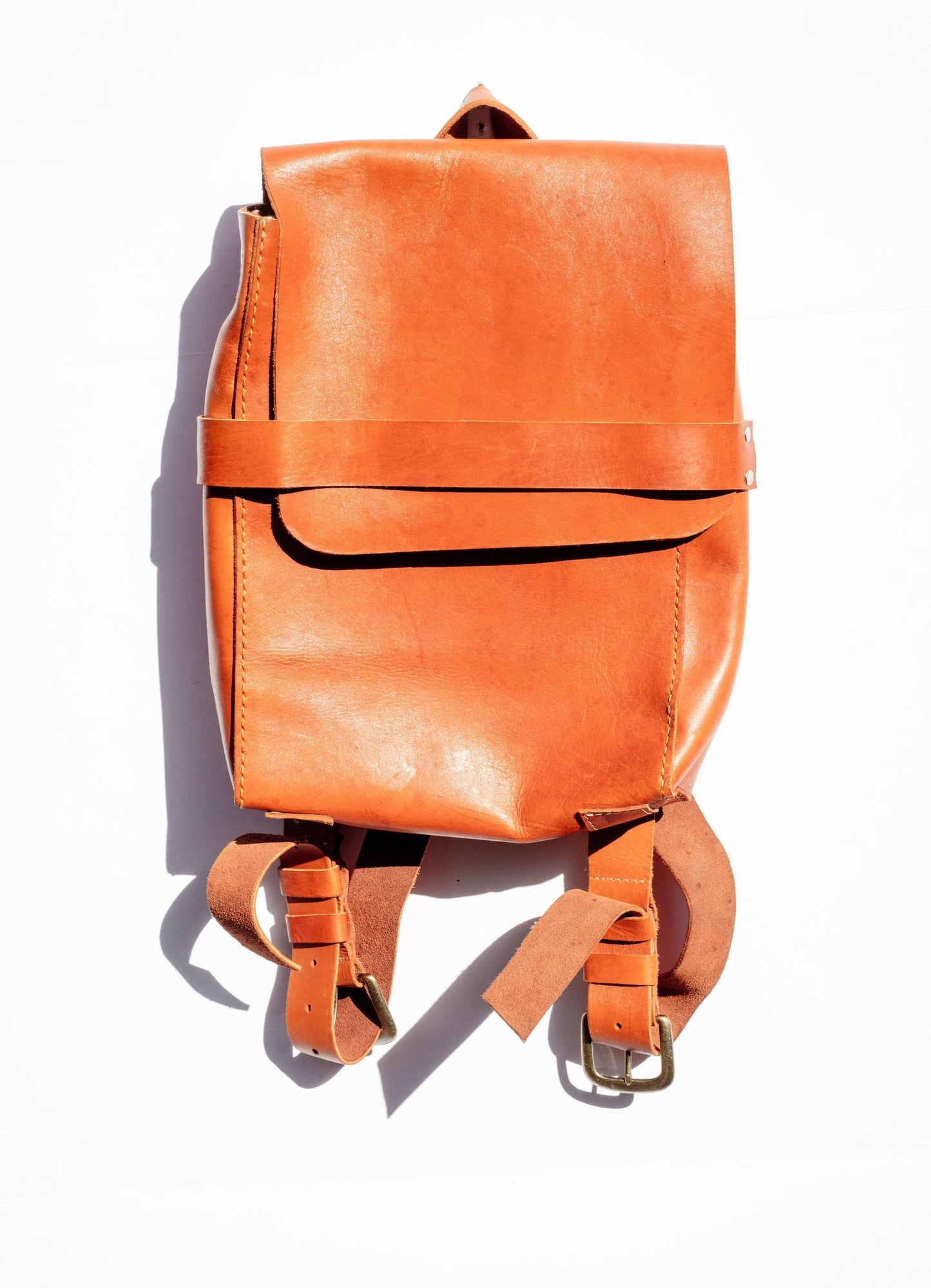 The Simon Leather Backpack handcrafted in Haiti with adjustable straps and secure key ring in natural brown leather