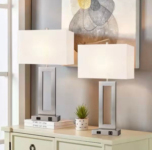 Two LamQee 20 in. brushed nickel touch control bedside table lamps with white fabric shades on a beige console table.