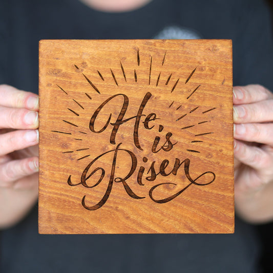 Handcrafted antique chestnut wooden block engraved with "He Is Risen" decorative script and sunburst design