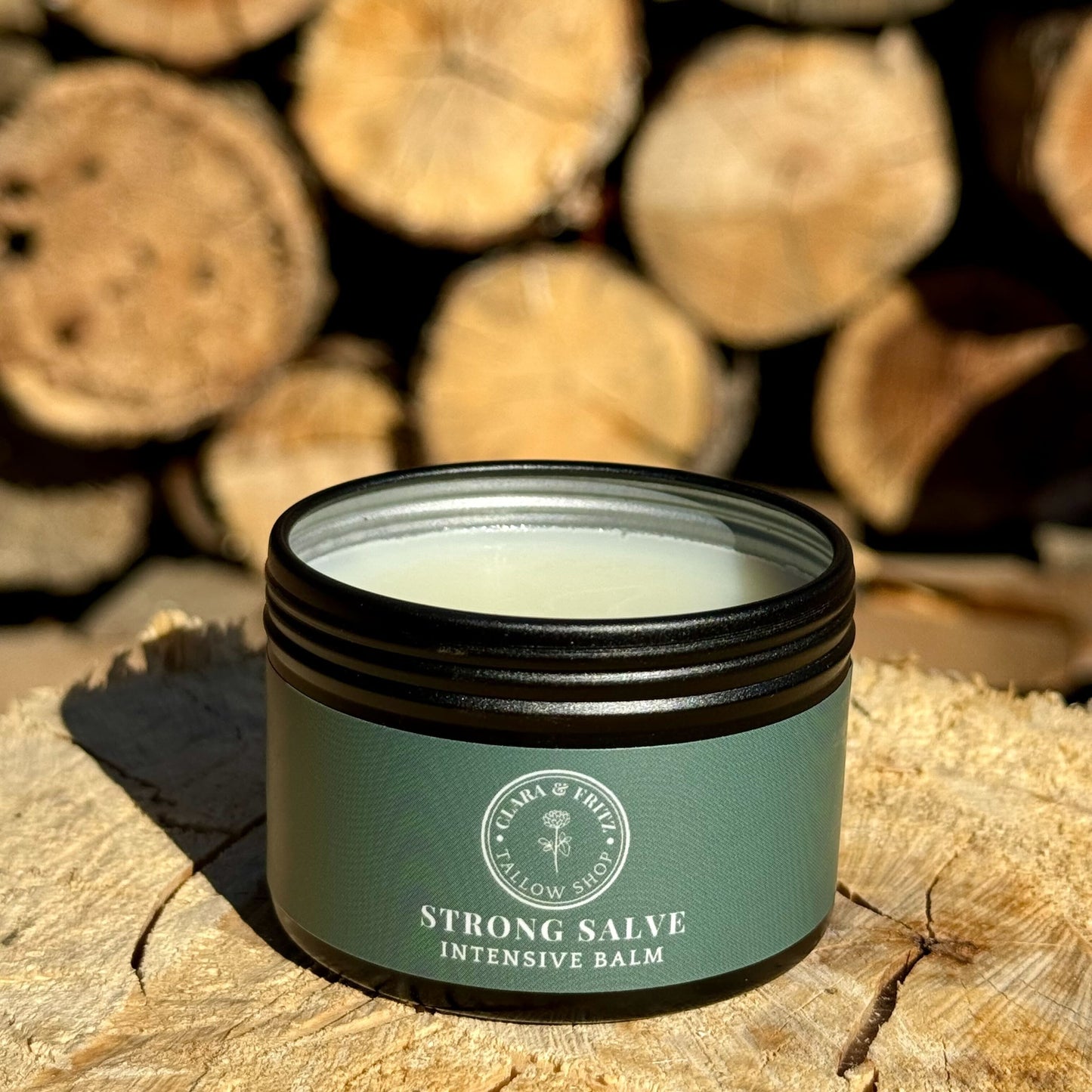 Jar of Strong Salve intensive balm with natural ingredients for moisturizing and skin repair on wooden surface