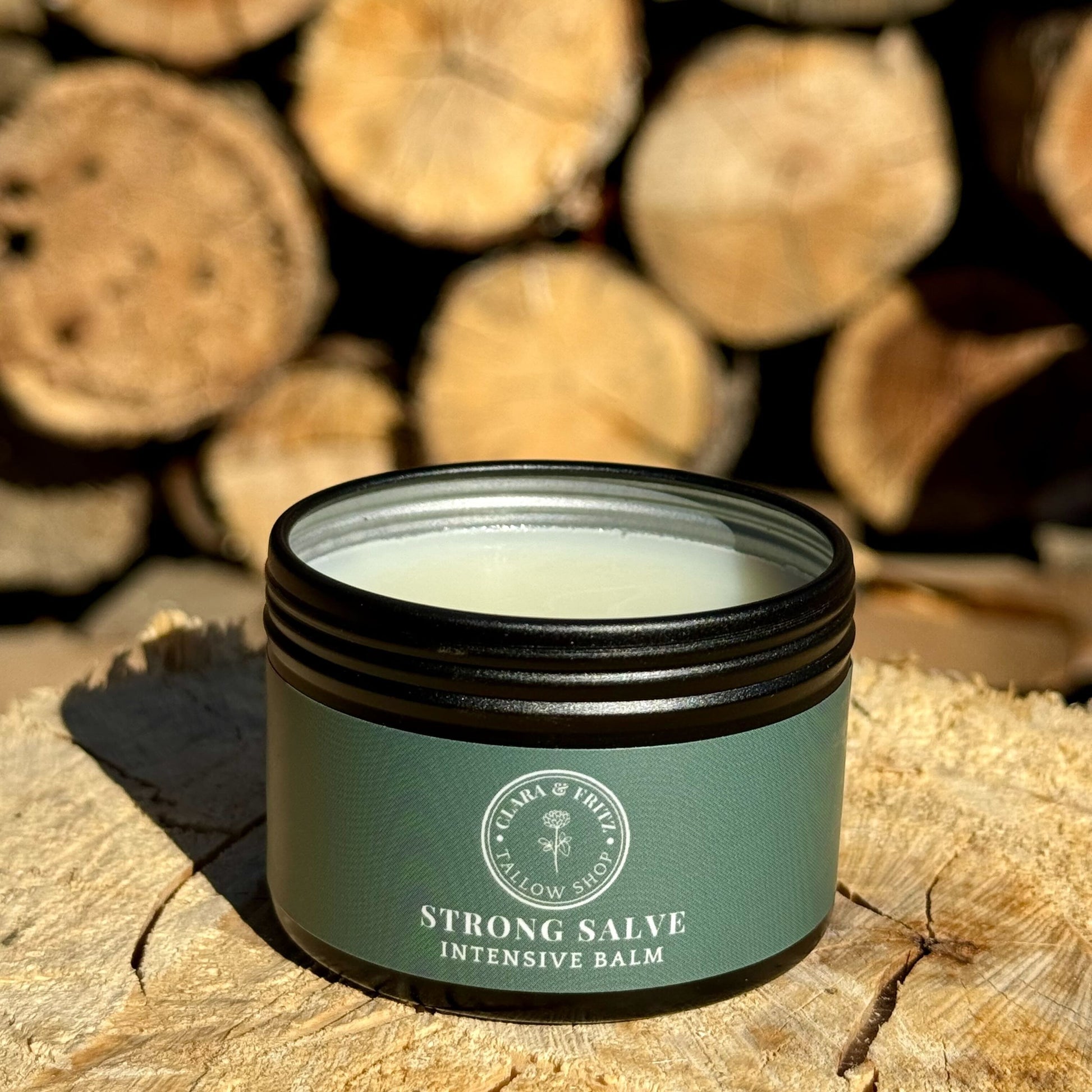 Jar of Strong Salve intensive balm with natural ingredients for moisturizing and skin repair on wooden surface