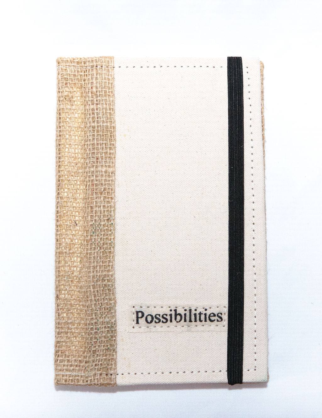 Eco-friendly fabric story journal with "Possibilities" label and black elastic band closure