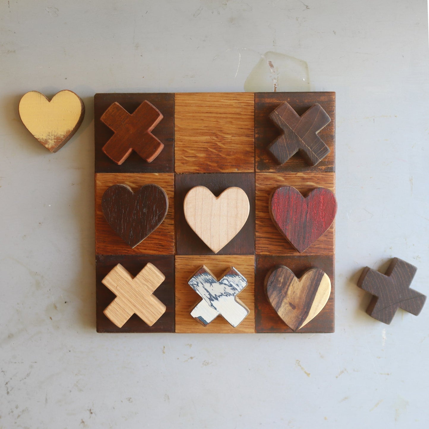 Handmade wooden Tic-Tac-Toe Heart Game with reclaimed wood hearts and X pieces on a square board
