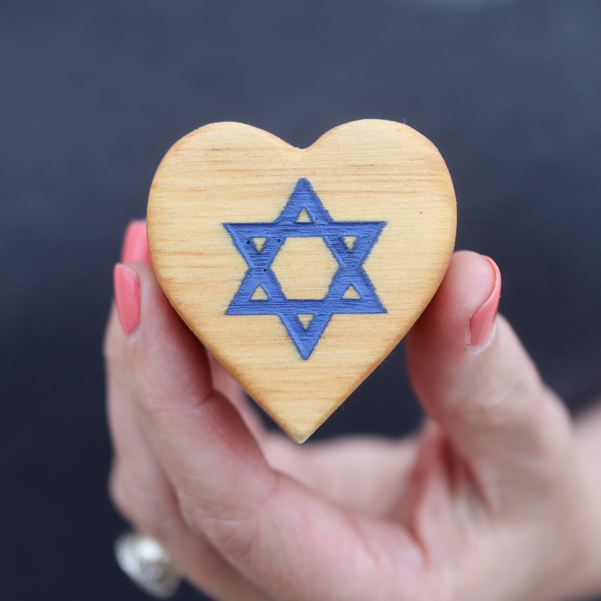 Handheld wooden heart with blue Star of David engraved, symbolizing Hearts for Peace in Israel.