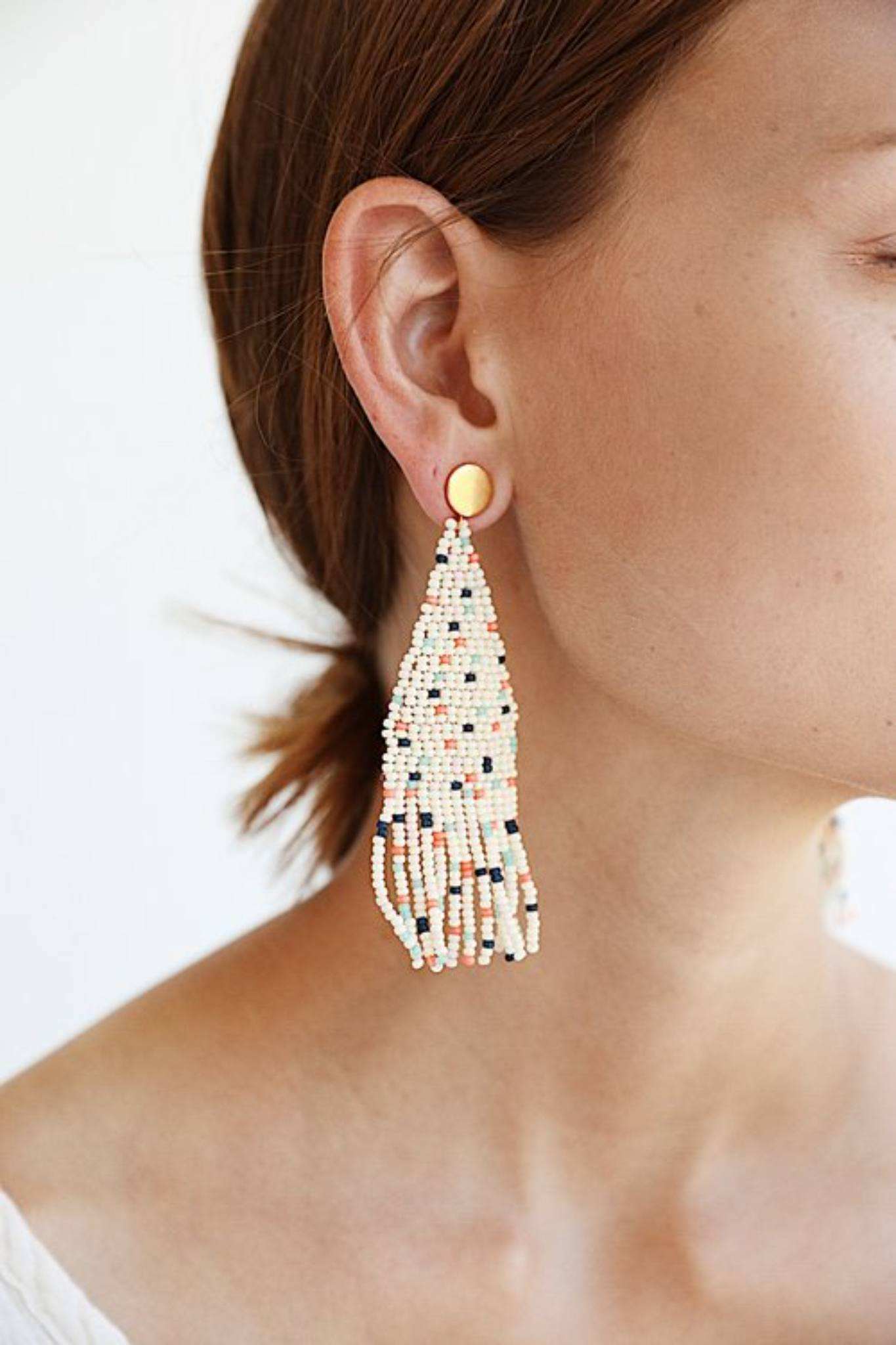 Annie Beaded Fringe Earring with handwoven glass beads and brass post in confetti colors worn on a woman's ear