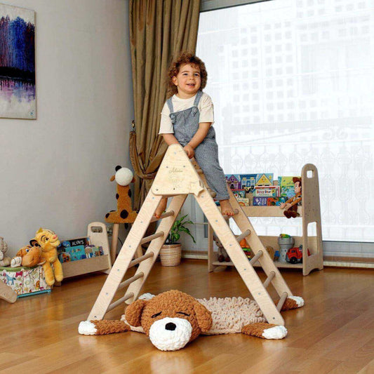 Toddler climbing on a foldable wooden Climbing Triangle with ramp in a cozy playroom setting