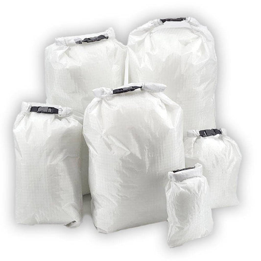 Set of six white ultralight roll top dry bags made from waterproof Challenge D50T fabric in various sizes for outdoor gear protection
