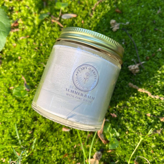 Glass jar of Summer Balm for Body with zinc oxide on green moss background