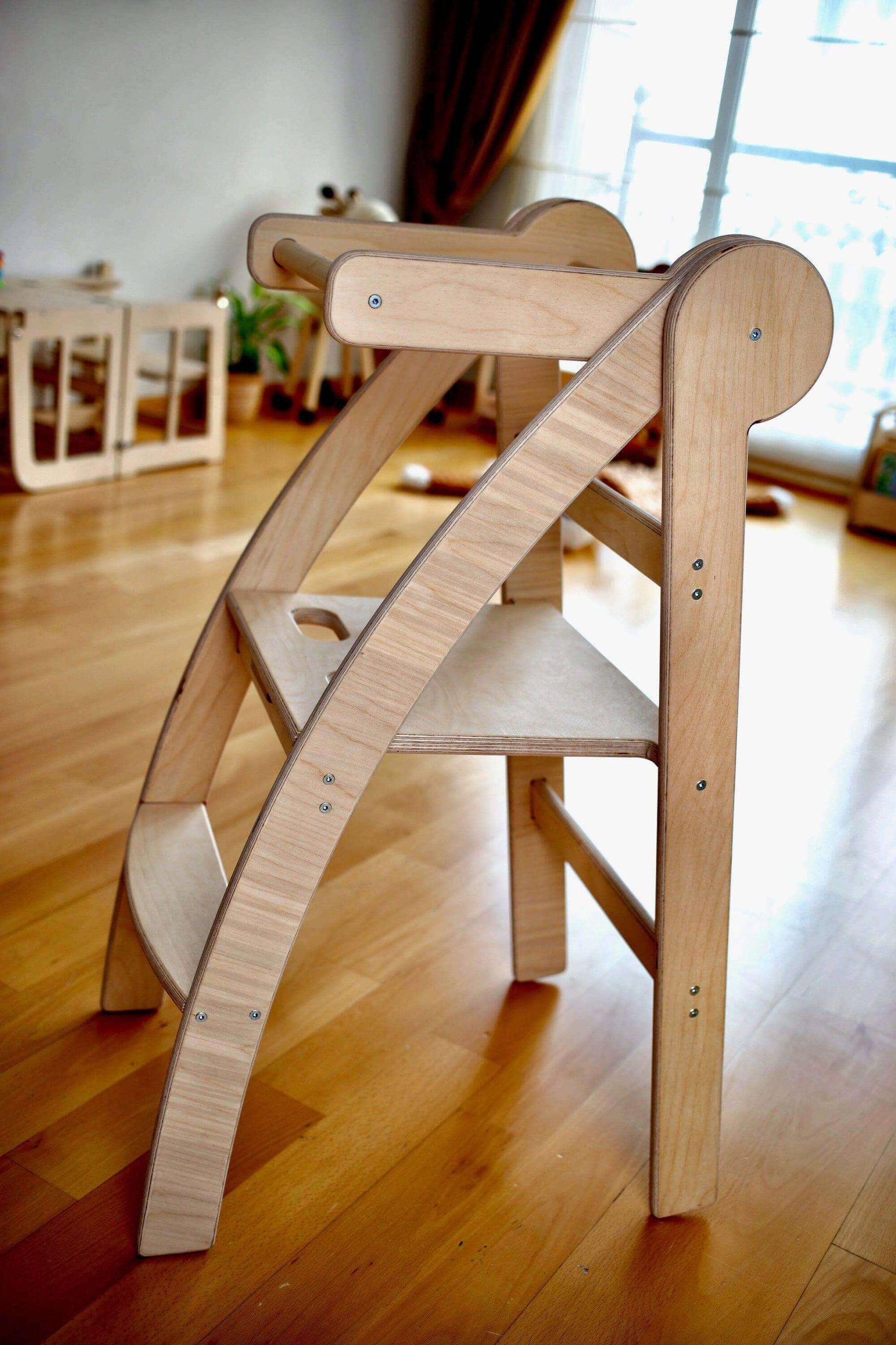 Foldable Montessori toddler tower made of natural birchwood, designed for safe child exploration and adjustable height.