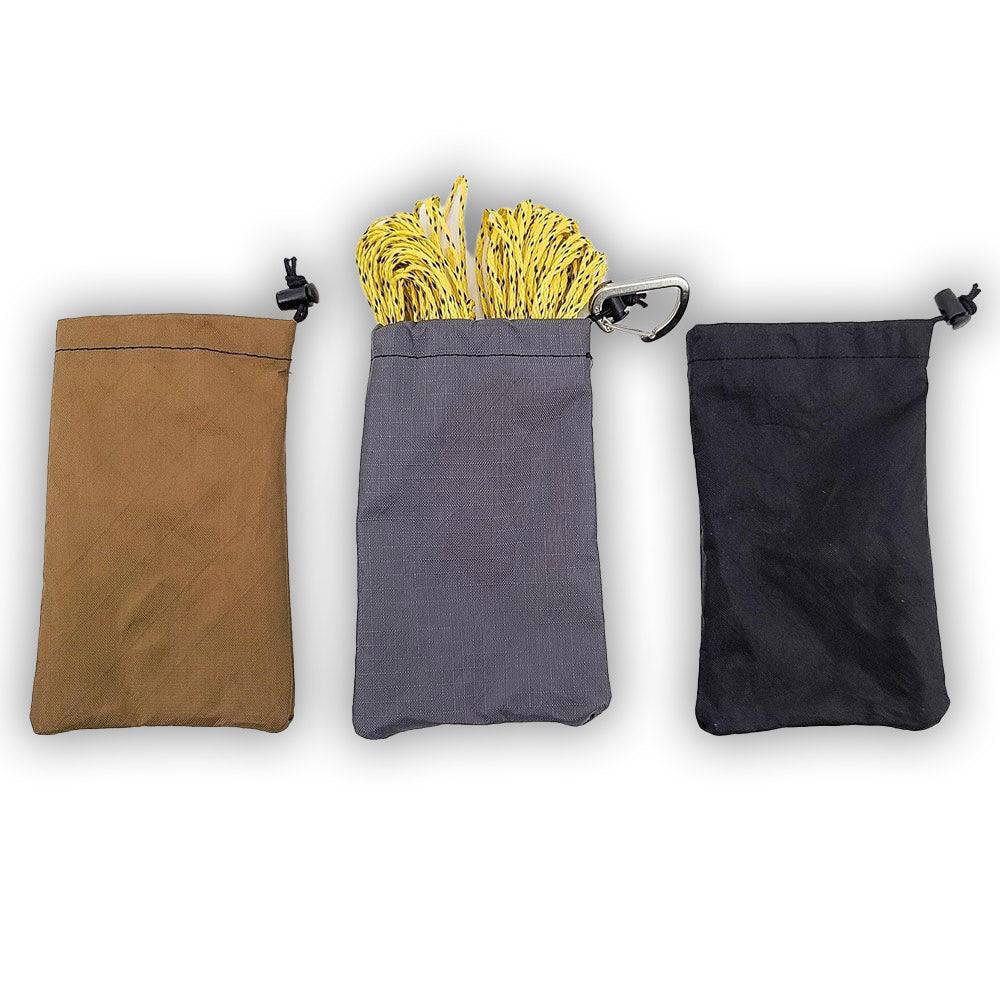 Three Rock Throw Bags (sacks) in brown, gray with yellow cord, and black made of ECOPAK material
