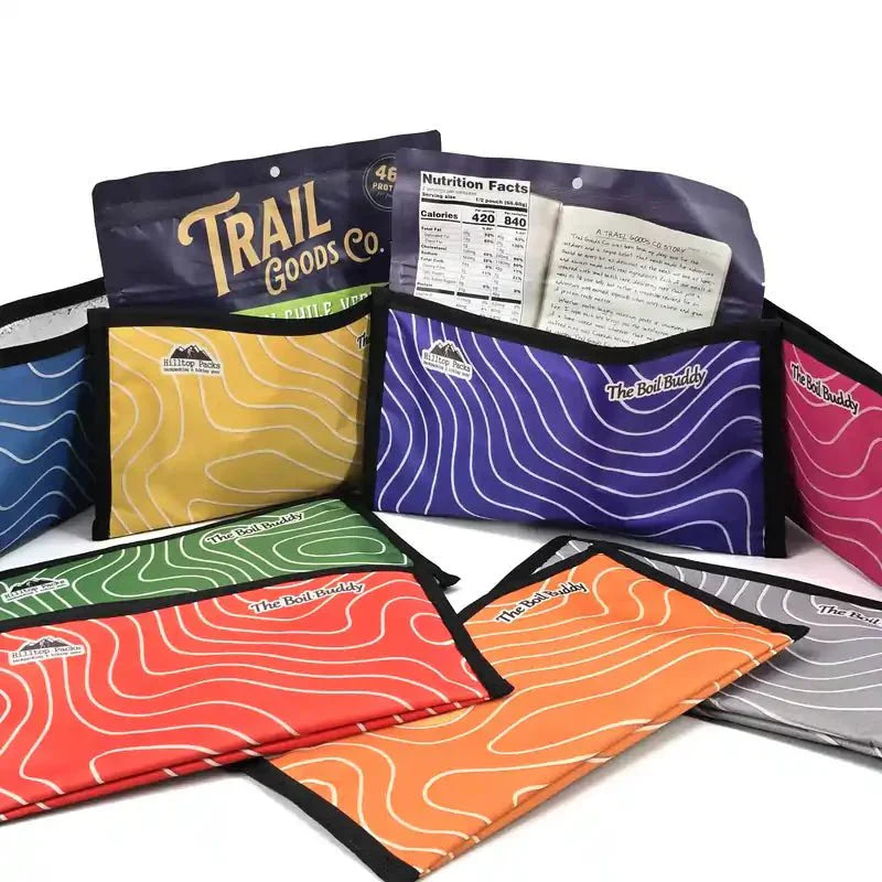 Colorful Boil Buddy insulated food pouches holding freeze-dried trail meal bags for hiking and camping.