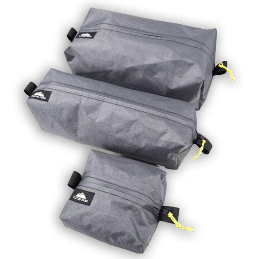 Set of three gray ultralight waterproof zipper boxes made from Ecopak EPLX200 fabric with yellow zipper pulls for hiking and backpacking gear organization