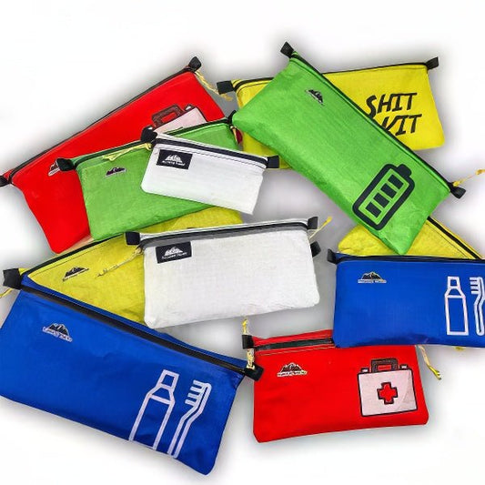 Colorful ultralight zipper pouches in red, green, blue, and white with various outdoor and first aid icons for organizing hiking gear.